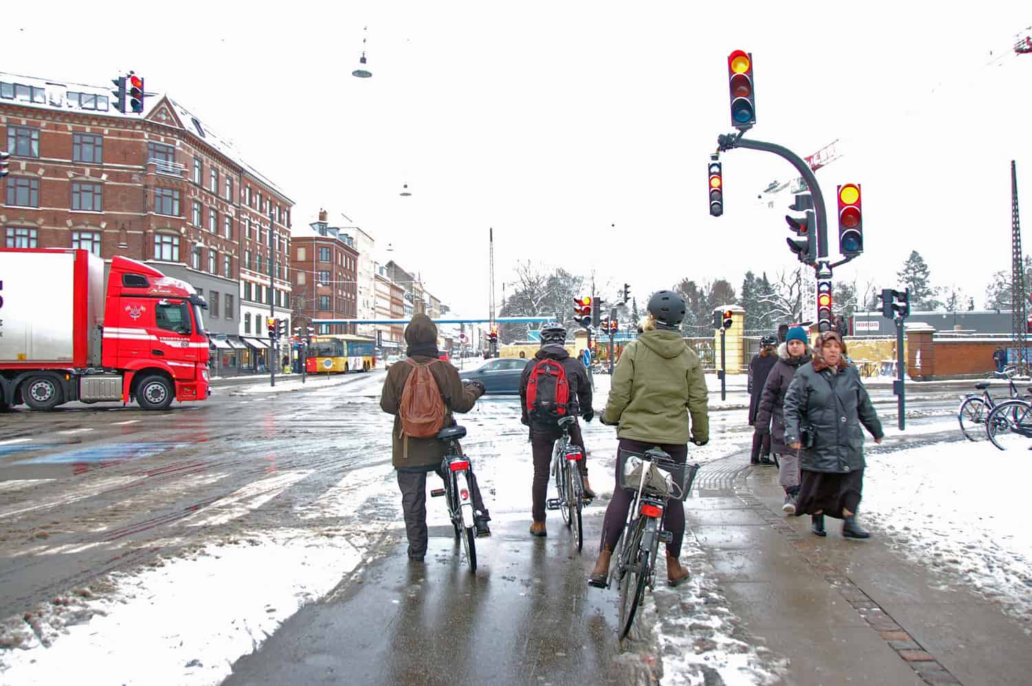 A snowy afternoon on Nørrebrogade in Copenhagen. Bike lights will turn green seconds before car lights to give the cyclists the first right of way. Cyclists feel safe riding in their designated lane.